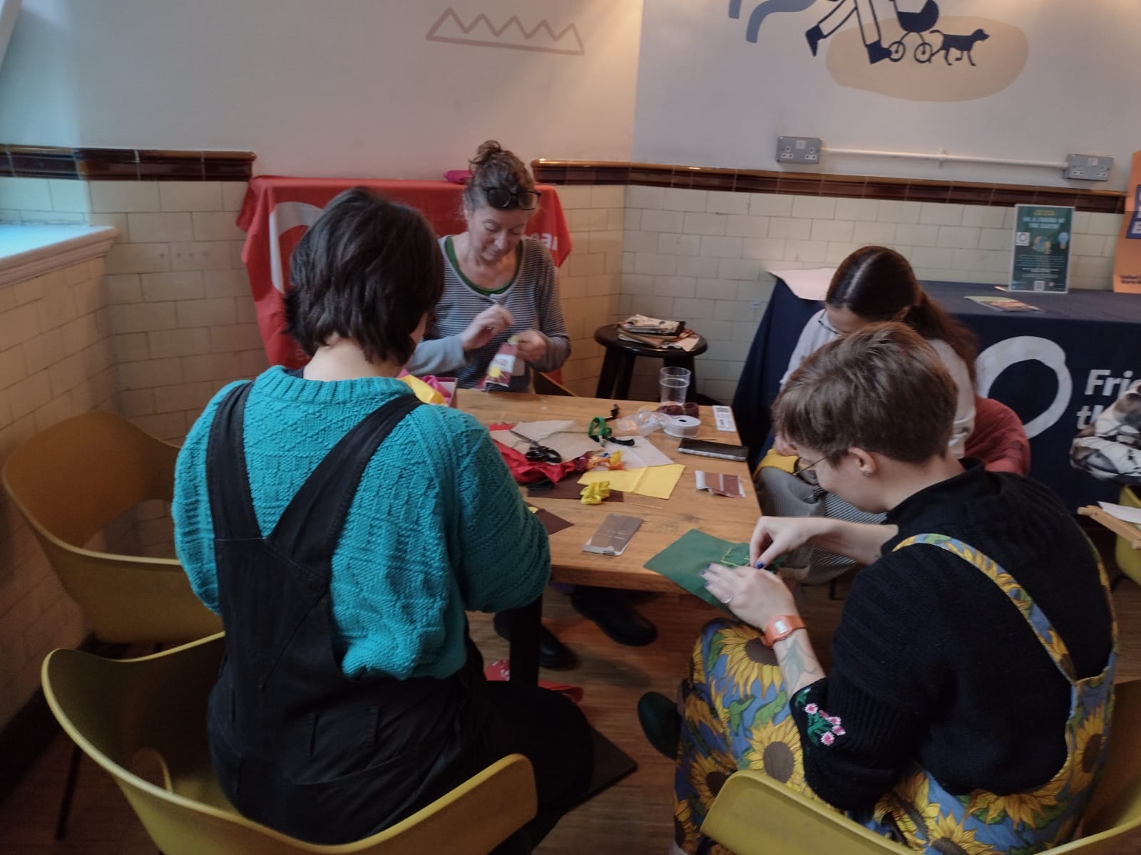People sitting around table making a quilt