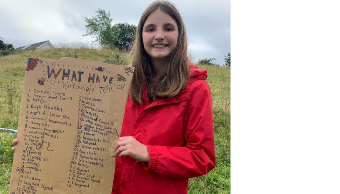 Child holding up a list of the bugs she found
