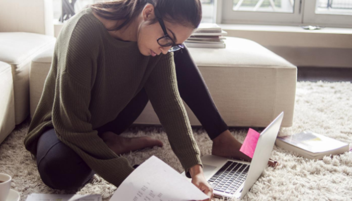 Picture of a woman working on a laptop on the floor
