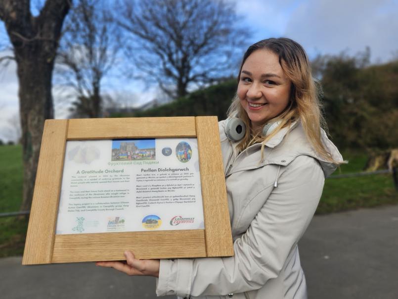 Lady holding a plaque in a park