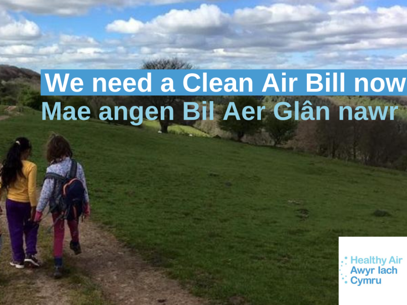 Photo of three children walking down a country road with hills in the distance and a blue sky with clouds