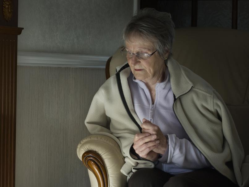 Elderly woman trying to keep warm