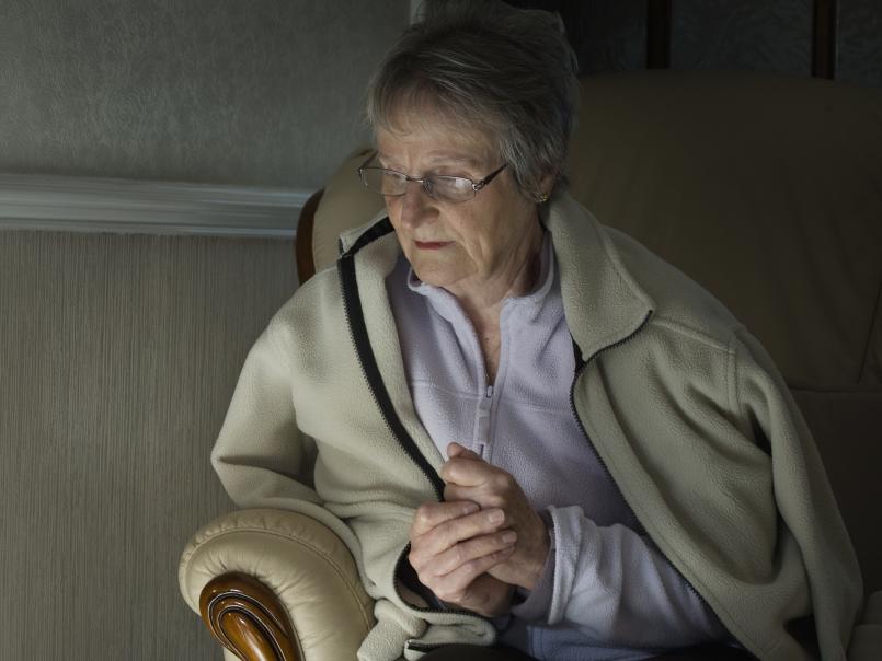 Elderly woman trying to keep warm