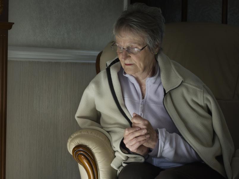 Elderly woman trying to keep warm