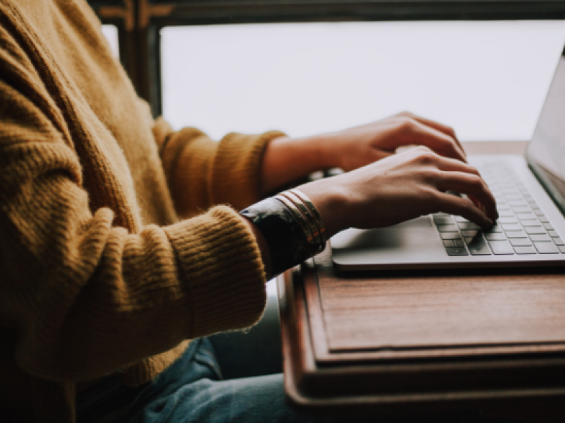 Person typing into a laptop