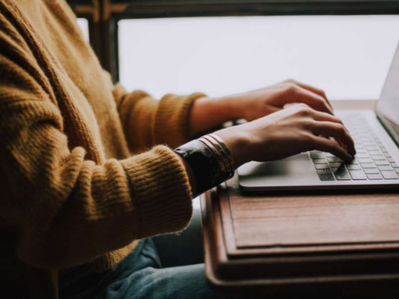 Someone typing at a laptop