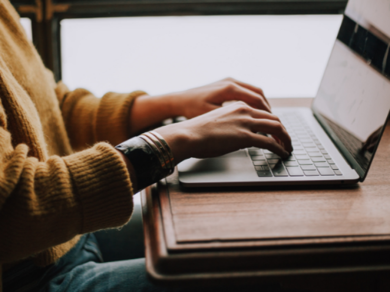 Someone typing at a laptop