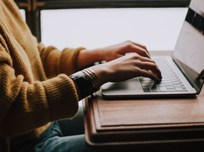 Photo of a person typing on a laptop