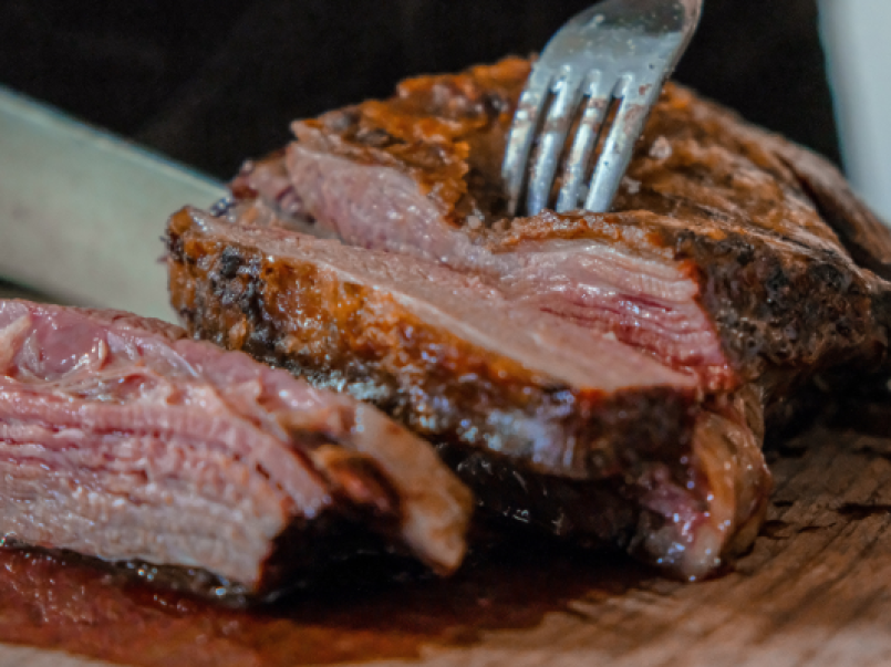 Someone cutting through a joint of meat