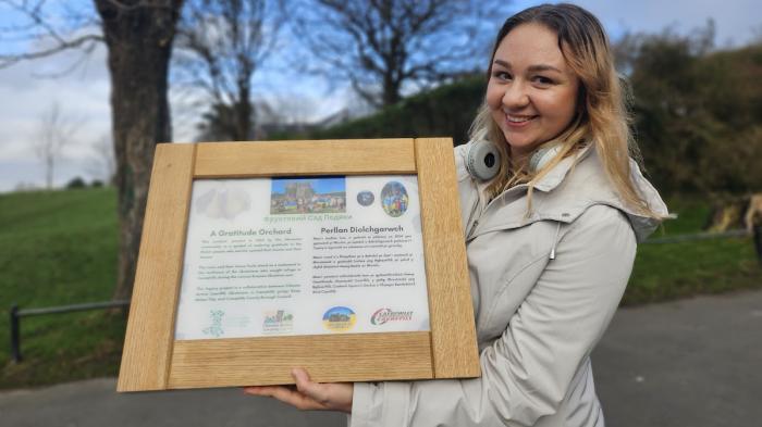 Lady holding a plaque in a park