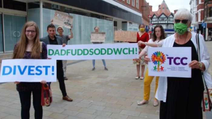 Picture of three people holding divest placards